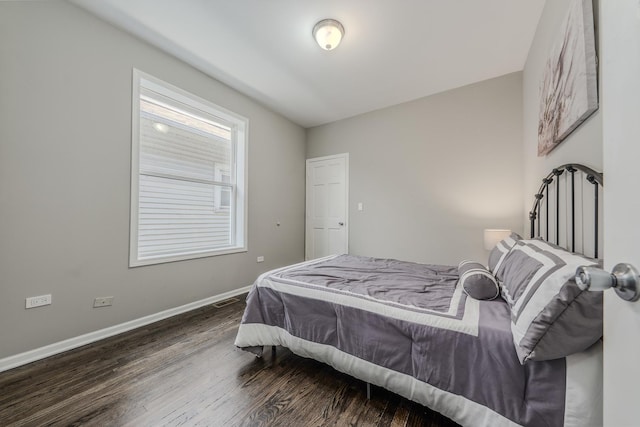 bedroom with dark hardwood / wood-style floors