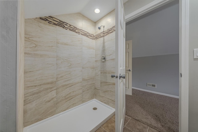 bathroom with tiled shower and tile patterned flooring