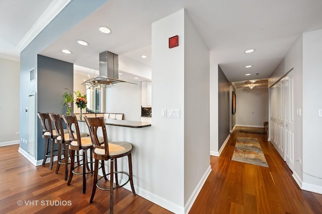 1250 S Michigan Ave Unit 2900, Chicago, IL 60605 - kitchen with a kitchen bar, island exhaust hood, wood finished floors, and recessed lighting