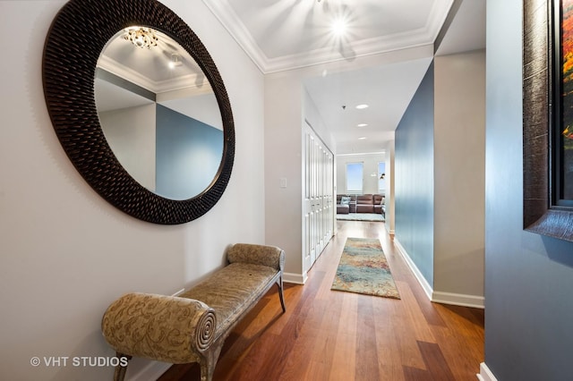 corridor featuring crown molding, baseboards, and wood finished floors