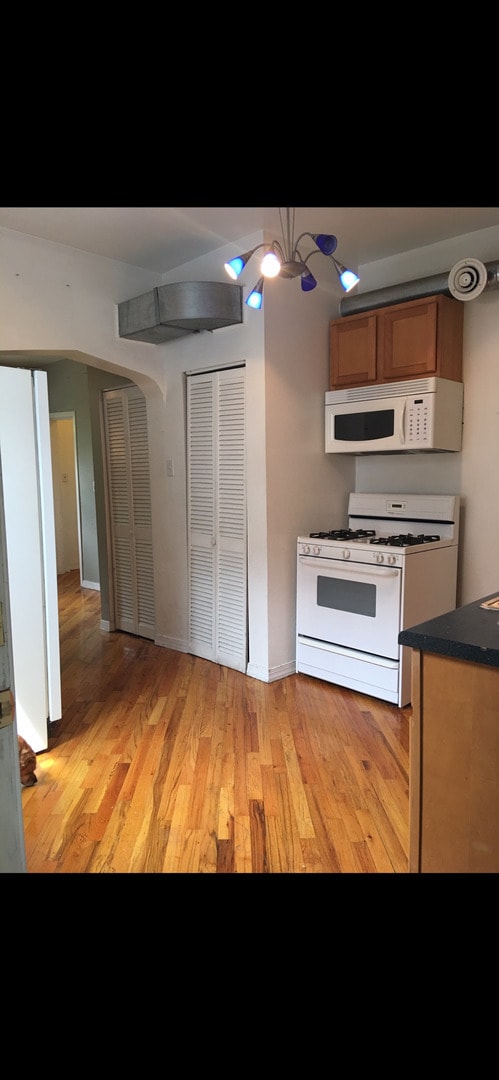 2215 N Talman Ave, Chicago, IL 60647 - kitchen featuring white appliances, a chandelier, and light hardwood / wood-style flooring