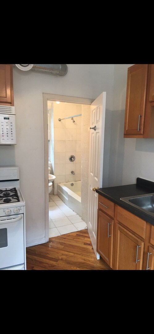 kitchen featuring sink, light hardwood / wood-style flooring, and white appliances