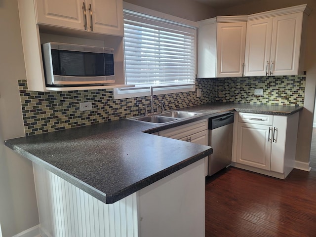 kitchen with sink, white cabinets, appliances with stainless steel finishes, and decorative backsplash