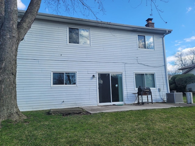 back of house with cooling unit, a patio, and a yard