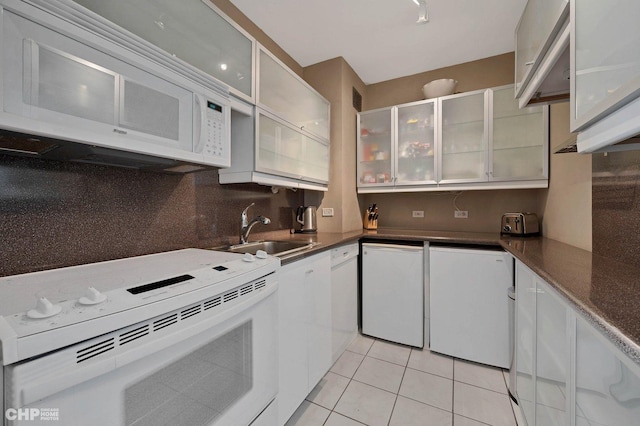 kitchen featuring sink, white cabinetry, light tile patterned floors, white appliances, and decorative backsplash