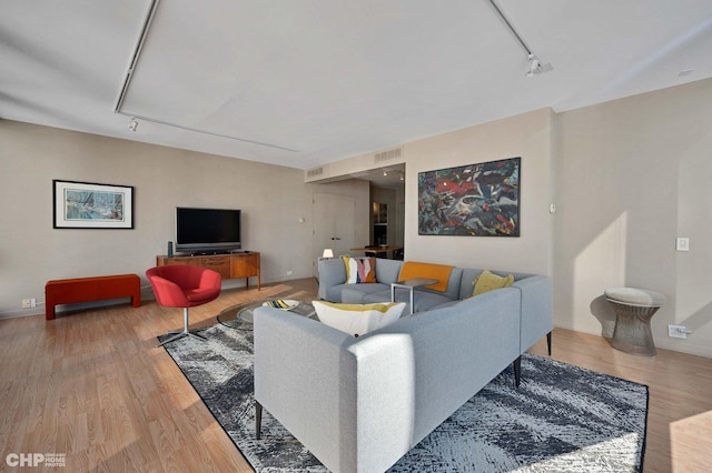 living room featuring wood-type flooring and rail lighting