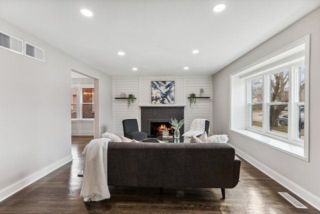 living room with a fireplace and dark hardwood / wood-style flooring