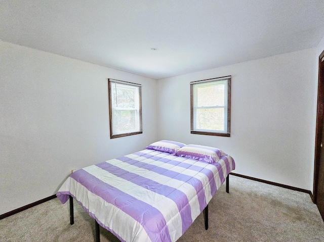 carpeted bedroom featuring multiple windows