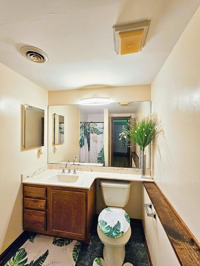 bathroom featuring tile patterned flooring, toilet, and vanity