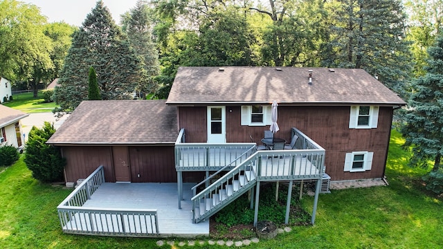 back of property with a wooden deck and a lawn