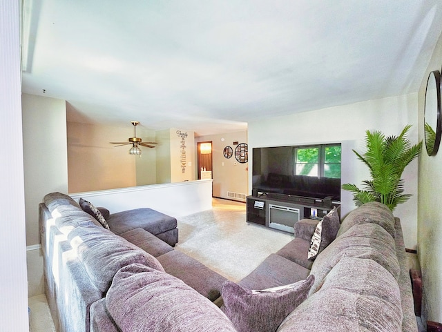 carpeted living room with ceiling fan