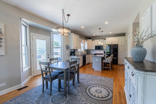 dining space featuring a chandelier, light hardwood / wood-style flooring, and sink