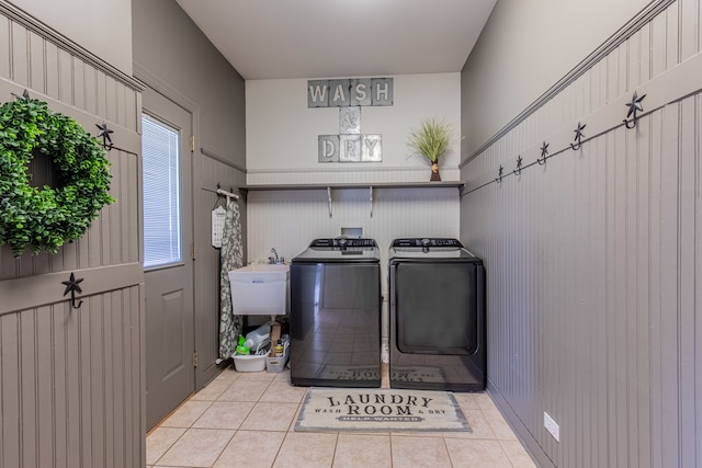 laundry room featuring washing machine and dryer, sink, and light tile patterned flooring