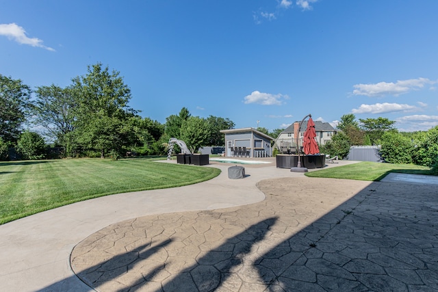 view of property's community featuring a lawn and a patio