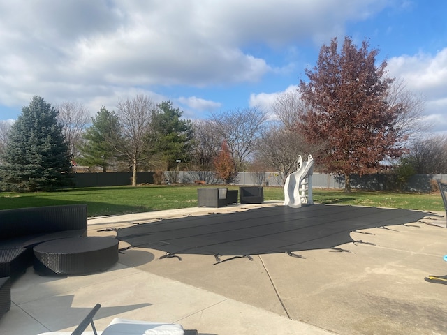 view of swimming pool featuring a lawn and a patio