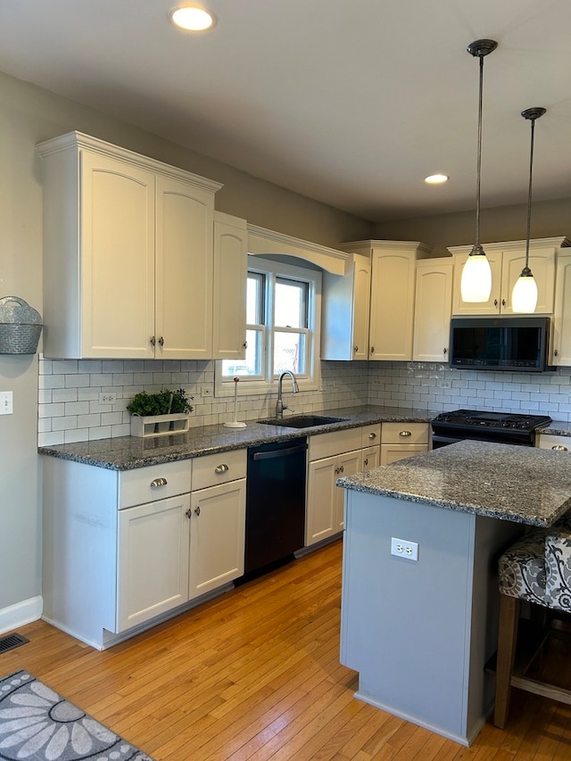 kitchen featuring black appliances, sink, light hardwood / wood-style flooring, decorative backsplash, and white cabinetry