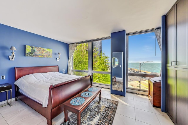 bedroom featuring a water view, light tile patterned flooring, and a baseboard heating unit