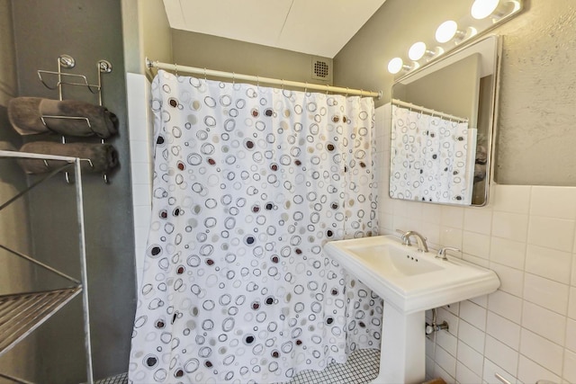 bathroom featuring tile walls and a shower with curtain