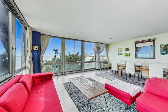 living room featuring floor to ceiling windows, a water view, and light tile patterned floors