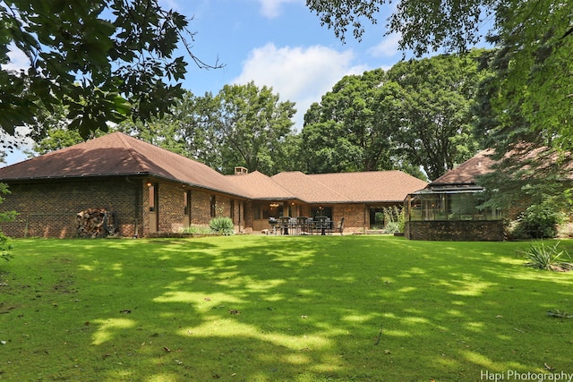 back of property featuring a patio area and a lawn