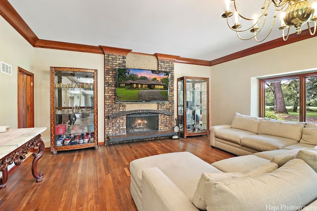 living room with a fireplace, crown molding, a chandelier, brick wall, and dark hardwood / wood-style flooring