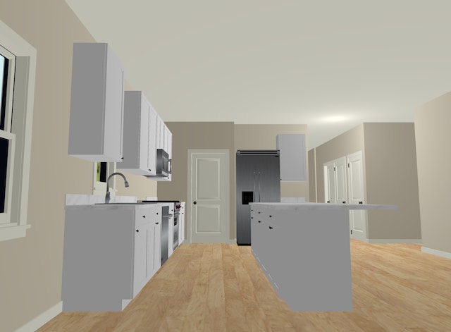 kitchen featuring built in refrigerator, white cabinets, a kitchen island, sink, and stove