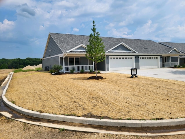 ranch-style home with a porch, a garage, and central air condition unit