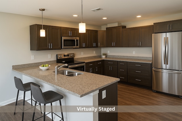 1109 S 2nd St, Oregon, IL 61061 - kitchen featuring appliances with stainless steel finishes, dark brown cabinets, a peninsula, decorative light fixtures, and recessed lighting