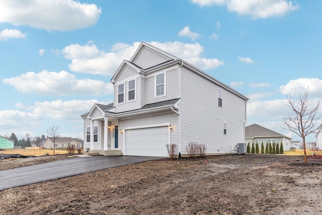 view of front of property with a garage and central air condition unit