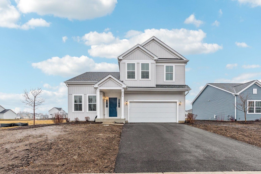 view of front of house with an attached garage, aphalt driveway, and board and batten siding