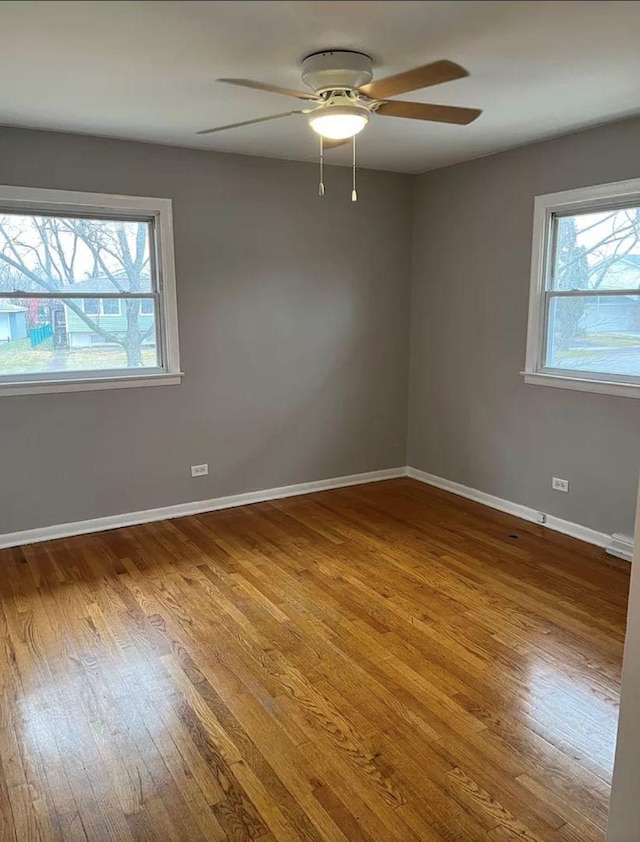 empty room with hardwood / wood-style floors and ceiling fan