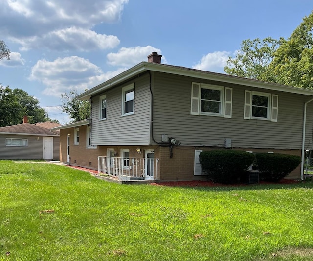 exterior space featuring cooling unit and a front yard