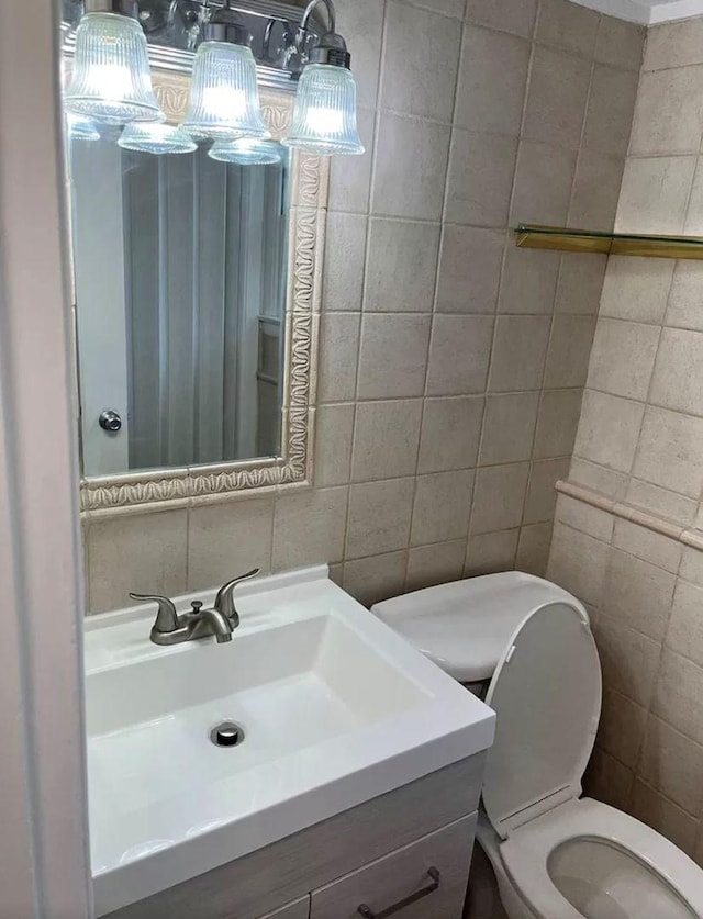 bathroom with tile walls, vanity, tasteful backsplash, and toilet