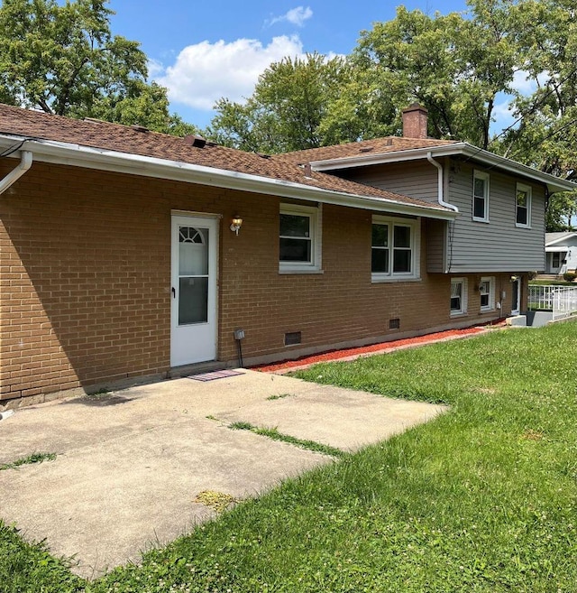 back of house with a patio and a lawn