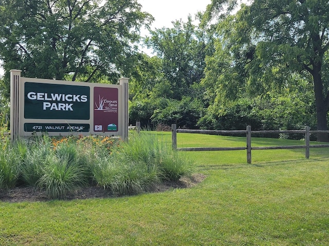 view of community featuring a lawn and fence