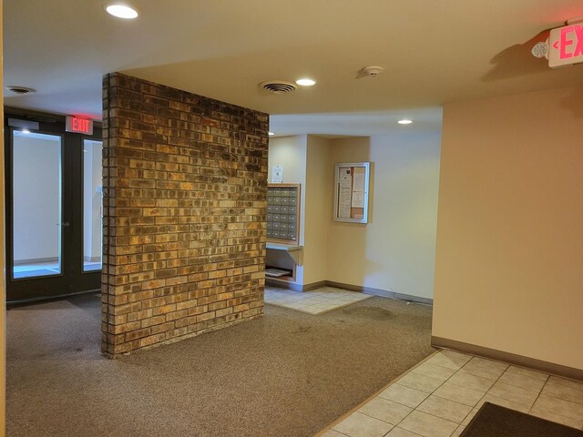 interior space with light carpet and brick wall