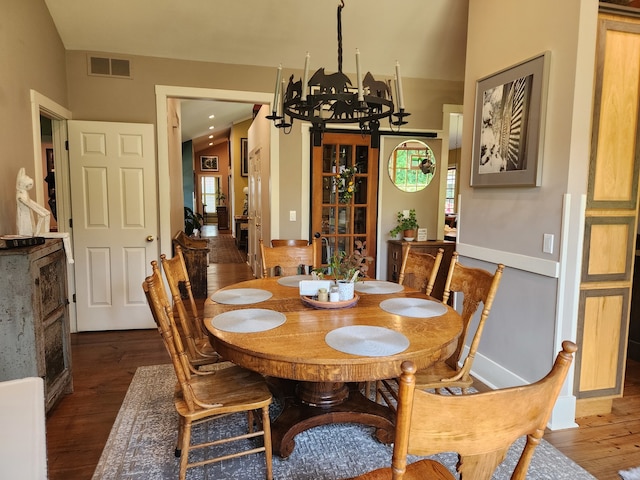 dining space with a notable chandelier and dark hardwood / wood-style flooring