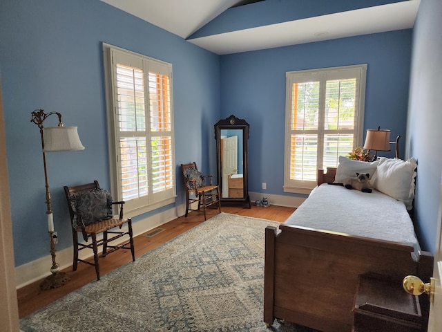 bedroom with lofted ceiling and light hardwood / wood-style floors