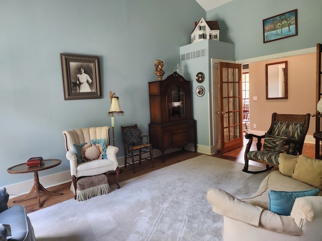 living area with high vaulted ceiling and hardwood / wood-style floors