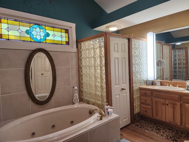 1726 Georgetown Dr, Champaign, IL 61821 - bathroom with a jetted tub, wood finished floors, vanity, and tile walls