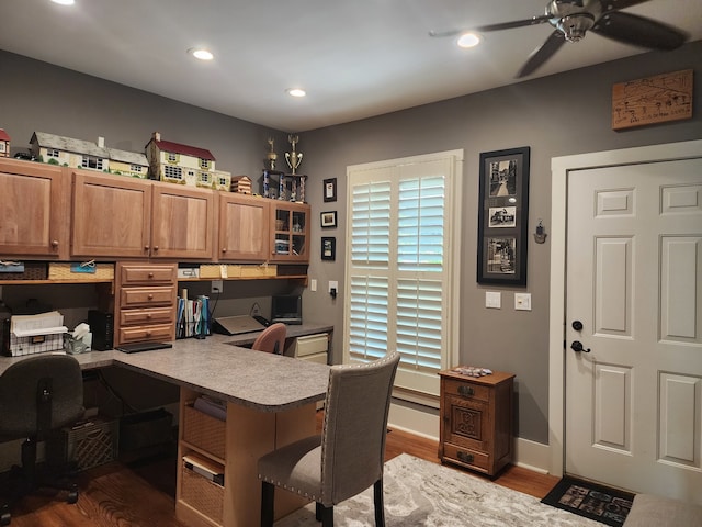 office space with built in desk, dark hardwood / wood-style floors, and ceiling fan