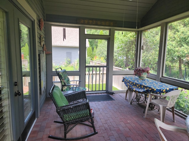 sunroom with plenty of natural light and vaulted ceiling