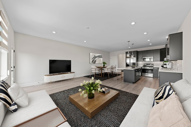 living room with sink and light wood-type flooring