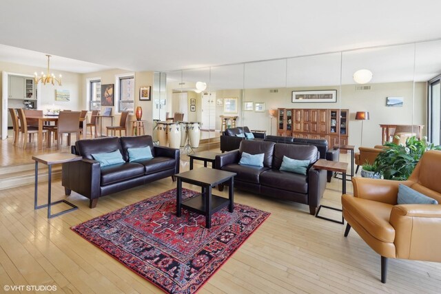 living room with light wood-type flooring and a chandelier