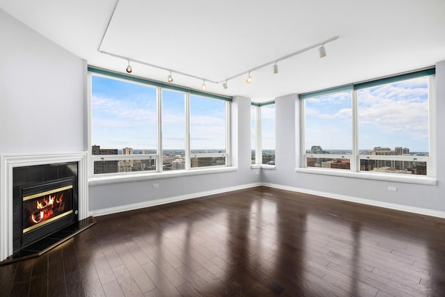 unfurnished sunroom featuring a glass covered fireplace, a wealth of natural light, and a city view