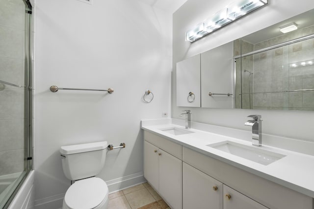 full bathroom featuring tile patterned flooring, a sink, toilet, and double vanity