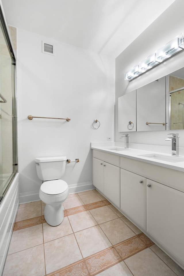 bathroom featuring toilet, a sink, visible vents, and tile patterned floors