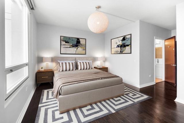 bedroom with baseboards and wood finished floors