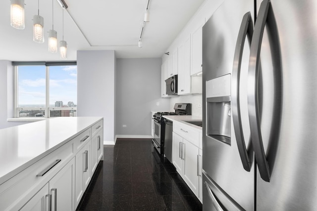 kitchen featuring light countertops, granite finish floor, appliances with stainless steel finishes, white cabinets, and baseboards