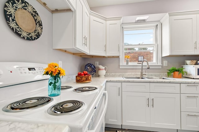 kitchen with white appliances, sink, and white cabinets